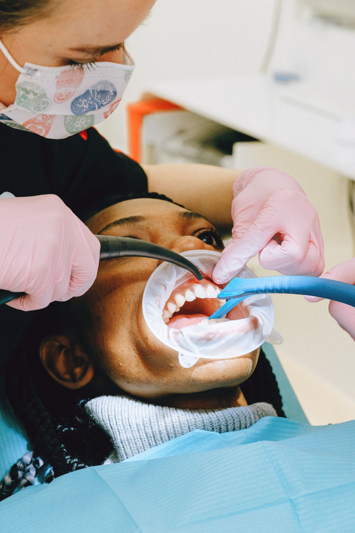 A hygienist's gloved hands during a check-up, close up